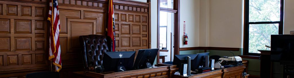 Interior view of an American courthouse in Kirksville, Missouri, featuring a judge's desk and flags.