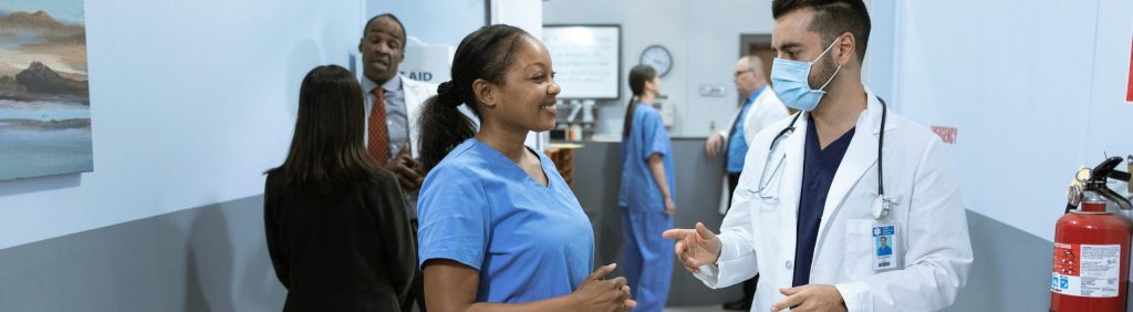 Doctors and nurses in a hospital hallway discussing medical matters.