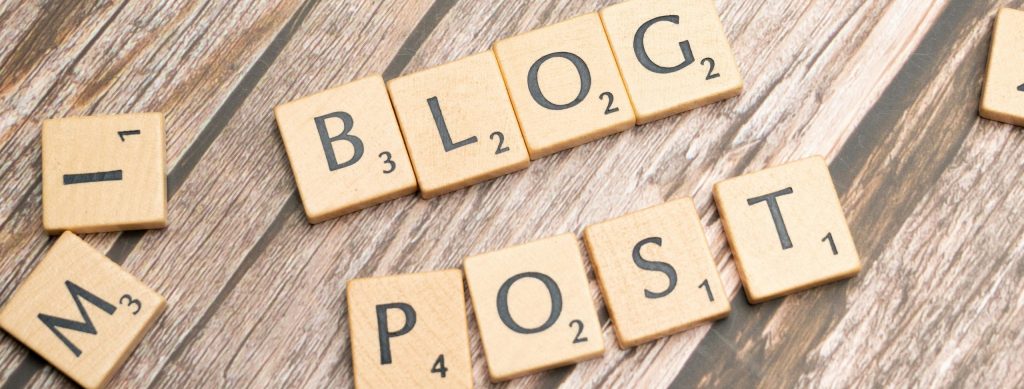 Wooden letter tiles spelling 'Blog Post' on a wooden background, ideal for online media concepts.